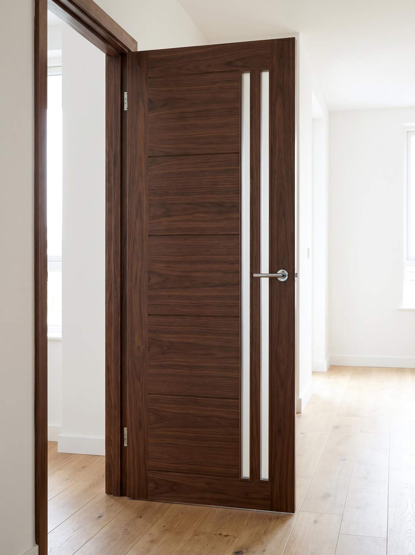 Usa de interior moderna din lemn de nuc inchis cu insertii de sticla, montata intr-un hol luminos.